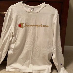 White champion shirt with gold “CHAMPION” letters